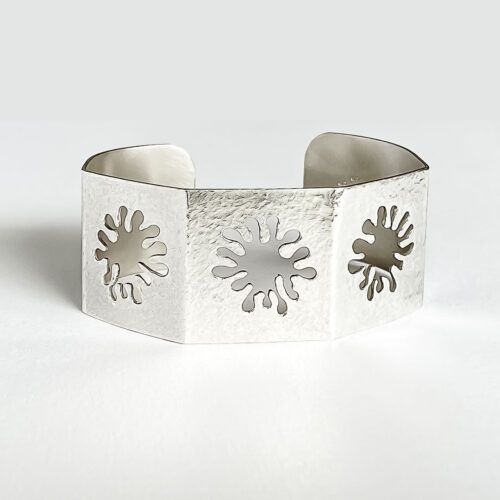 A unisex geometric cuff with coral cutouts and a matte finish.